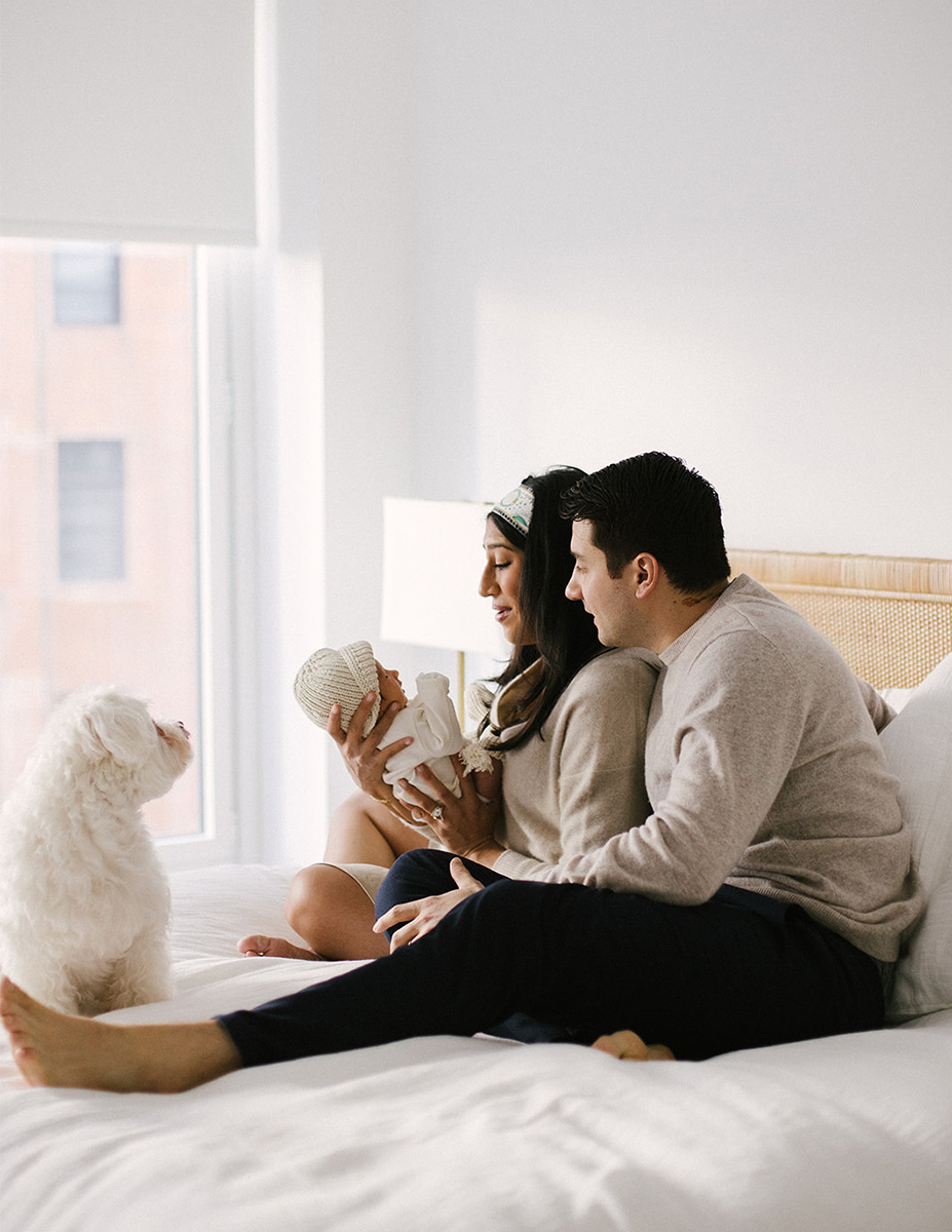 Familia con recién nacido en la cama de casa, sesión de fotografía lifestyle newborn