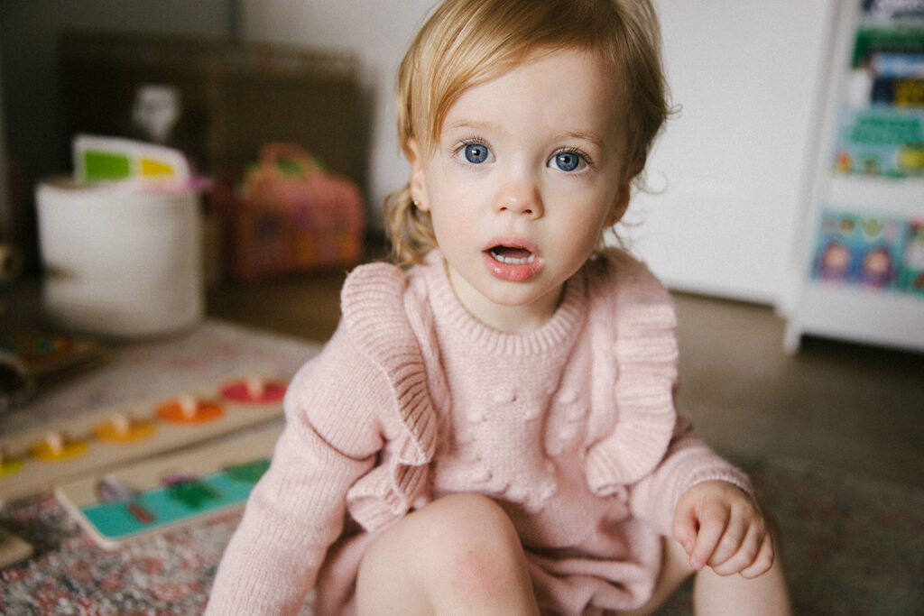 Fotografia de una niña de ojos azules en su casa.