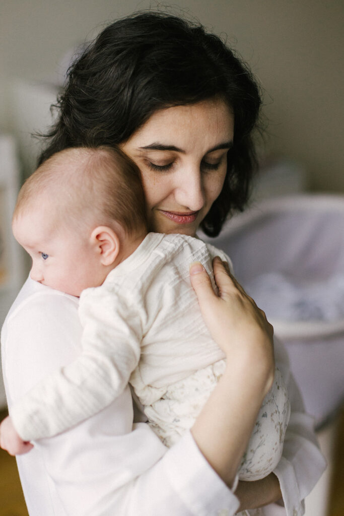 mama abrazando a su bebe recién nacido durante su sesión de fotos